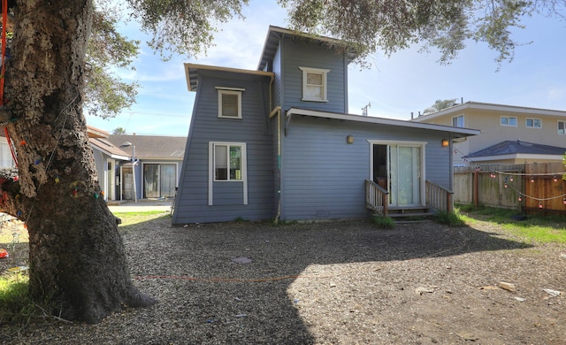 back of house with entry steps and fence