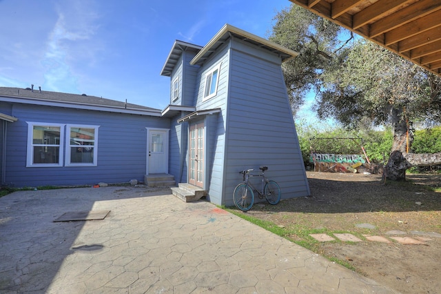 back of property with entry steps, french doors, and a patio area