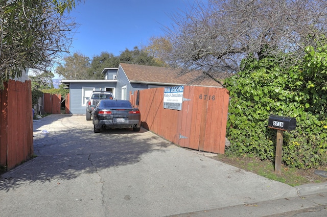 view of home's exterior with driveway and fence