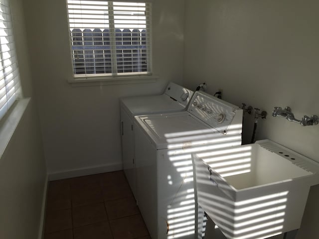 laundry area featuring tile patterned flooring, laundry area, washer and clothes dryer, and baseboards