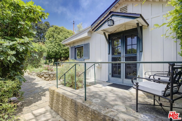 property entrance with a patio area and board and batten siding