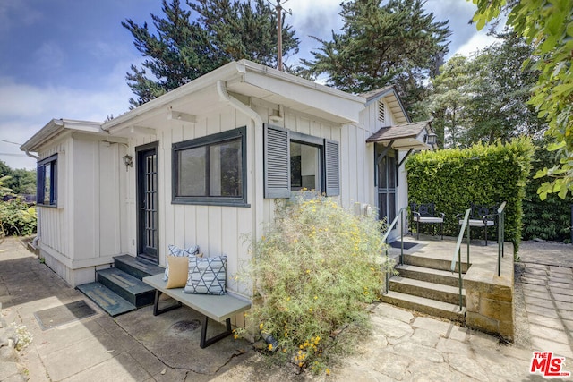 view of side of property with board and batten siding and entry steps