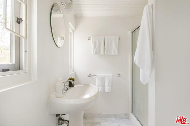 bathroom with a stall shower and a sink