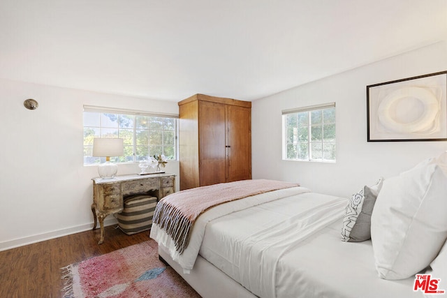 bedroom with baseboards and wood finished floors