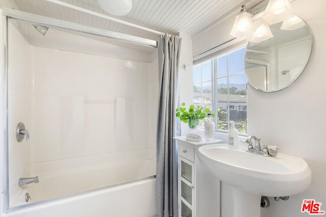 full bathroom with a sink and shower / bath combo with shower curtain