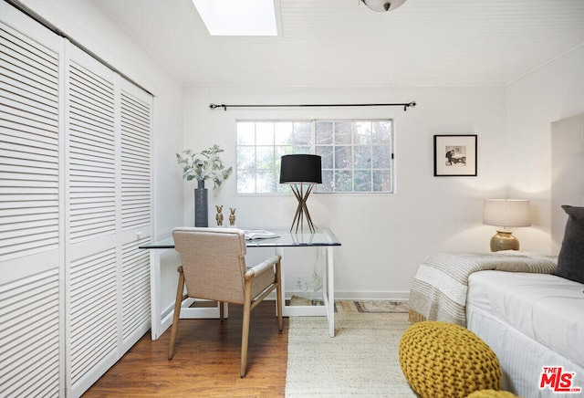 office with a skylight, baseboards, and wood finished floors