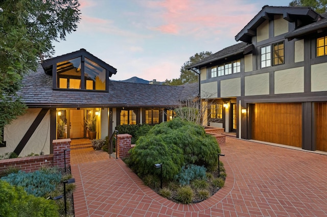 view of front of house with decorative driveway and stucco siding