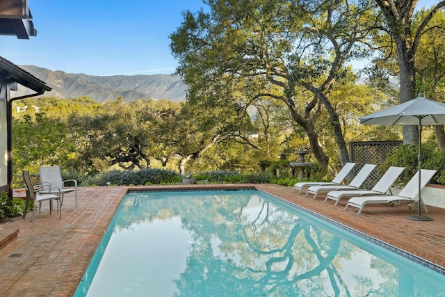 outdoor pool featuring a mountain view and a patio