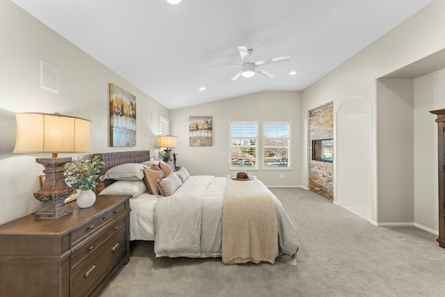 bedroom with baseboards, ceiling fan, carpet floors, vaulted ceiling, and a fireplace