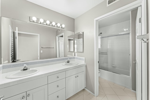 full bathroom with tile patterned flooring, double vanity, toilet, and a sink