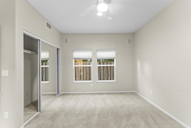 unfurnished bedroom featuring visible vents, multiple windows, a closet, and carpet flooring