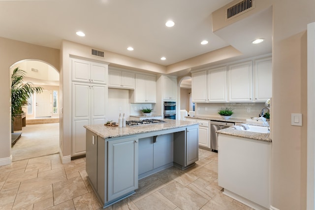 kitchen featuring arched walkways, visible vents, and appliances with stainless steel finishes