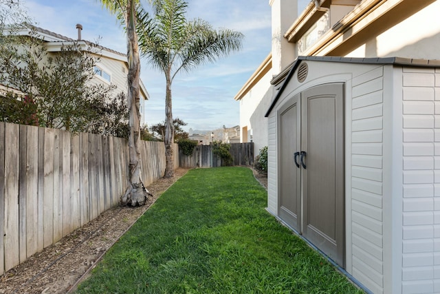 view of yard featuring an outbuilding, a shed, and a fenced backyard