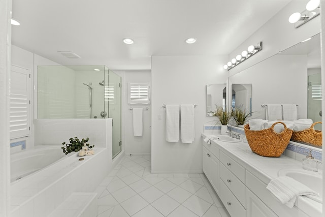 full bathroom featuring baseboards, a garden tub, double vanity, a stall shower, and a sink