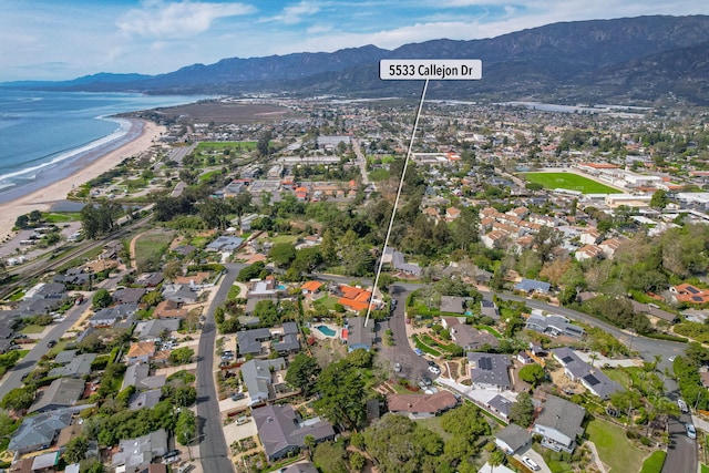 aerial view with a residential view, a beach view, and a water and mountain view