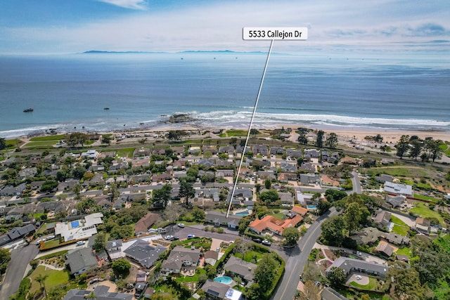 drone / aerial view with a residential view, a view of the beach, and a water view