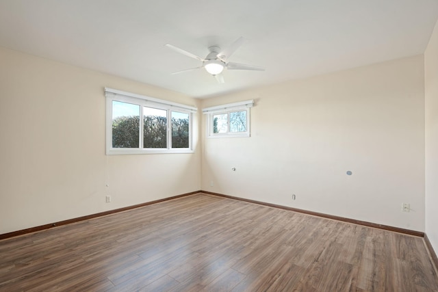 spare room with ceiling fan, baseboards, and wood finished floors