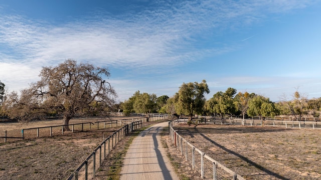 view of home's community with a rural view and fence