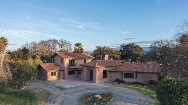 mediterranean / spanish home with driveway, a tiled roof, and stucco siding