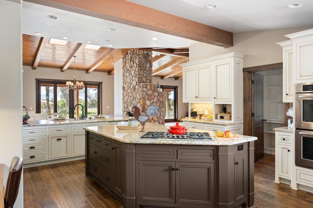 kitchen with wooden ceiling, appliances with stainless steel finishes, dark wood-style flooring, and a center island