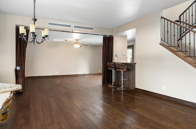 living area featuring stairway, hardwood / wood-style flooring, visible vents, and baseboards