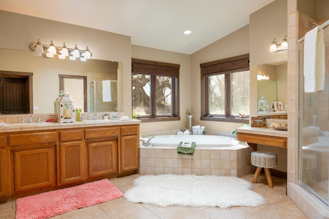 full bathroom featuring vaulted ceiling, a sink, a shower stall, a bath, and tile patterned floors