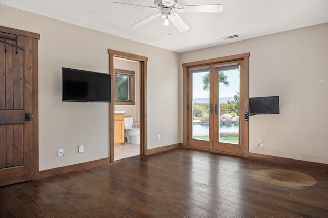 interior space with hardwood / wood-style flooring, baseboards, visible vents, and ceiling fan