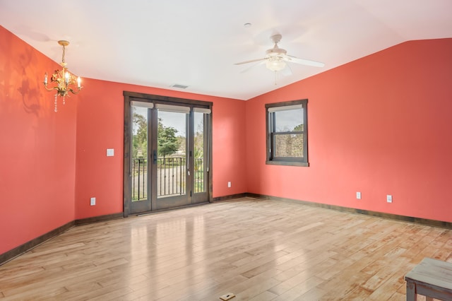 spare room with lofted ceiling, baseboards, visible vents, and wood finished floors