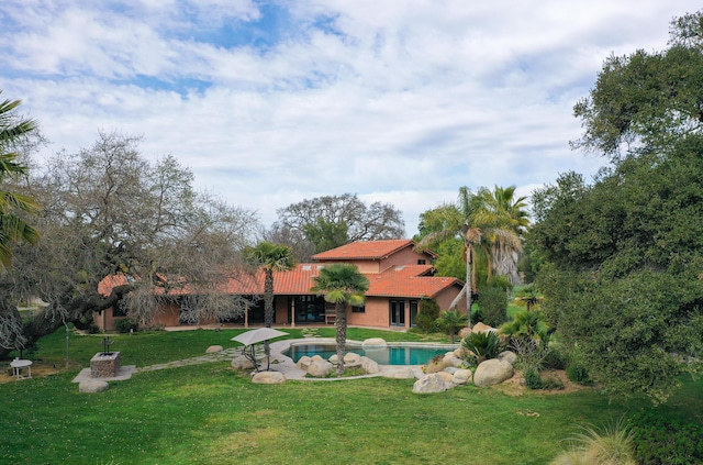 outdoor pool with a patio and a lawn