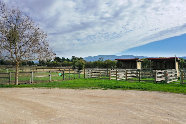 view of yard with a rural view, a mountain view, an exterior structure, and an outbuilding