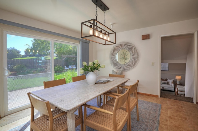 dining space featuring baseboards and light tile patterned flooring