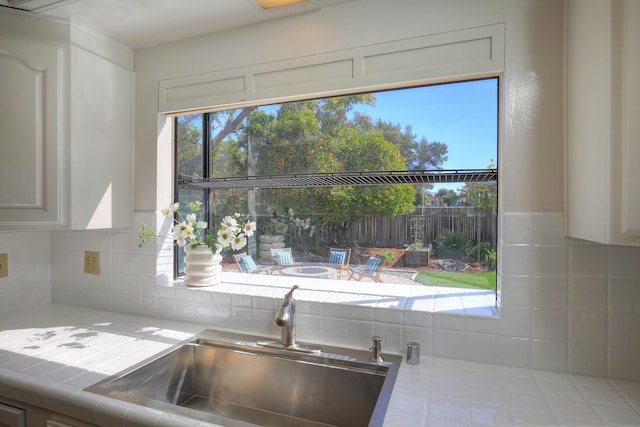 kitchen with decorative backsplash, tile countertops, and a sink