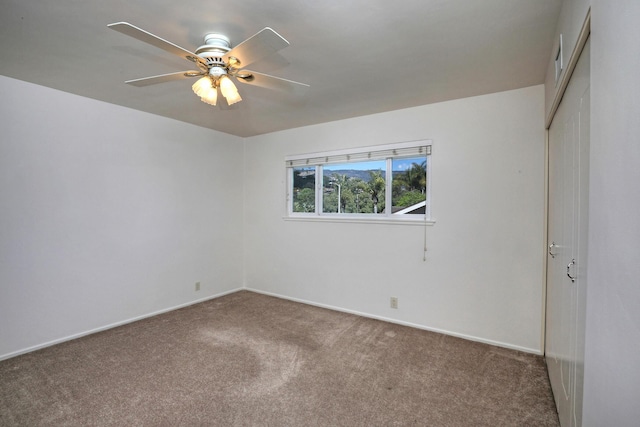 carpeted spare room featuring ceiling fan