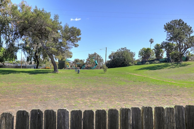 view of yard featuring fence and playground community