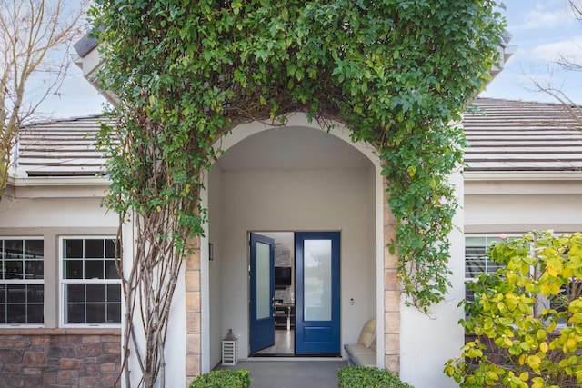 entrance to property featuring stucco siding