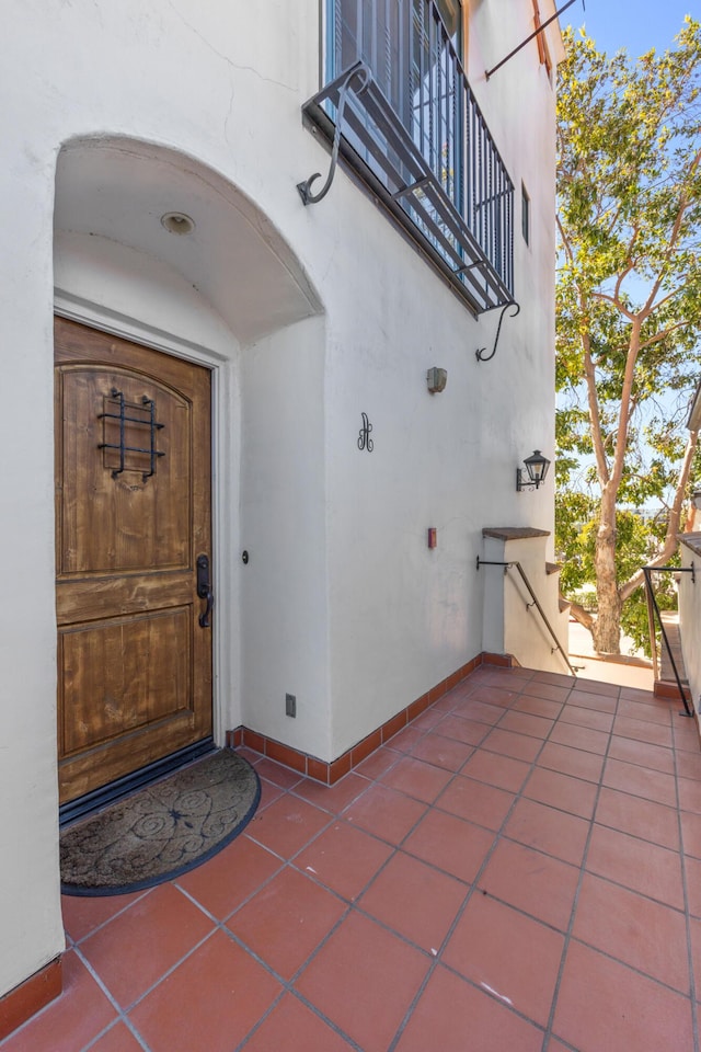 entrance to property featuring a patio area and stucco siding