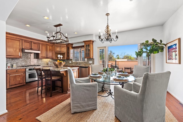 dining area featuring a chandelier, dark wood finished floors, and recessed lighting