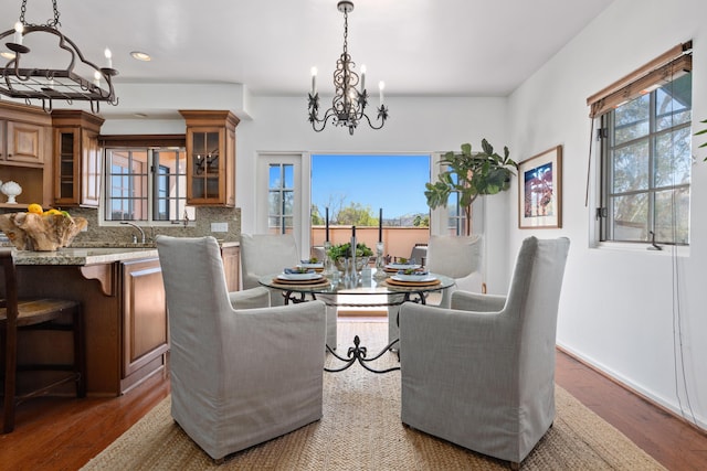 dining space featuring recessed lighting, an inviting chandelier, baseboards, and wood finished floors