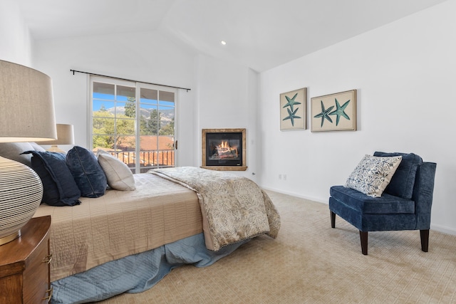 carpeted bedroom with access to exterior, baseboards, vaulted ceiling, and a glass covered fireplace