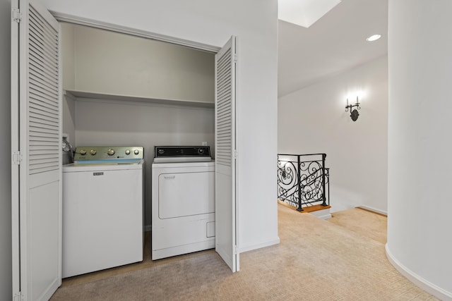 washroom with a skylight, washer and clothes dryer, recessed lighting, light carpet, and laundry area