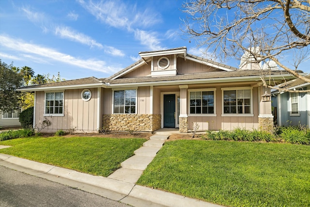 view of front facade featuring stone siding, board and batten siding, and a front yard