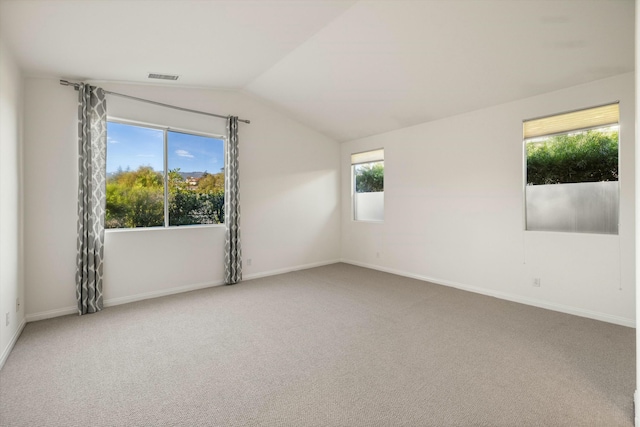 unfurnished room with vaulted ceiling, carpet, visible vents, and baseboards