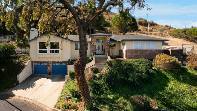 view of front of house with fence, brick siding, driveway, and stucco siding