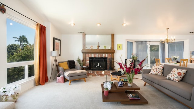 living room featuring visible vents, plenty of natural light, a notable chandelier, and a fireplace