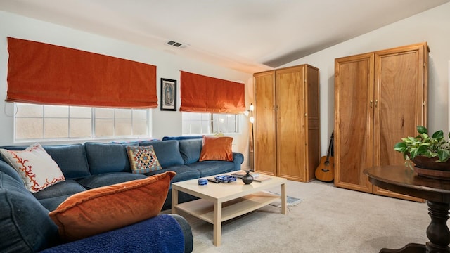 living area featuring lofted ceiling, light colored carpet, and visible vents