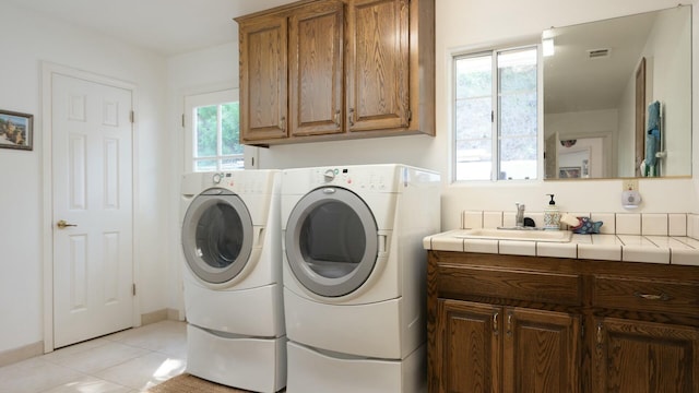 laundry room featuring visible vents, independent washer and dryer, a sink, cabinet space, and light tile patterned flooring