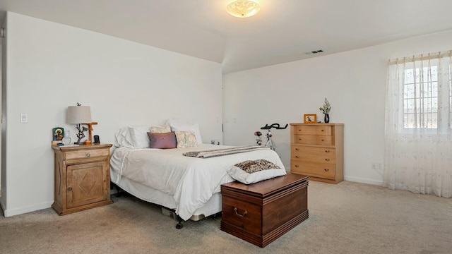 bedroom featuring baseboards, visible vents, light carpet, and lofted ceiling