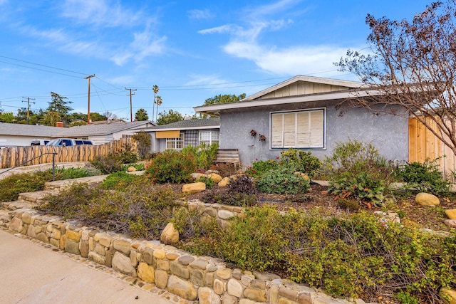 single story home featuring stucco siding and fence