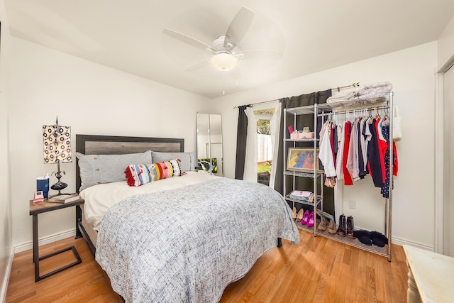 bedroom with a ceiling fan, light wood-type flooring, and baseboards