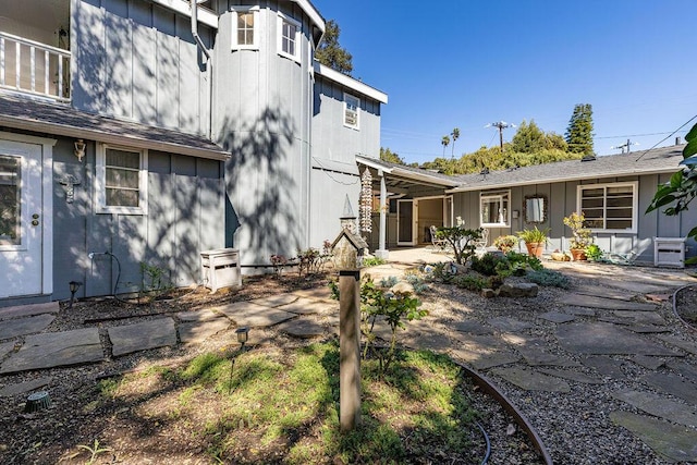 rear view of property with a patio area and board and batten siding